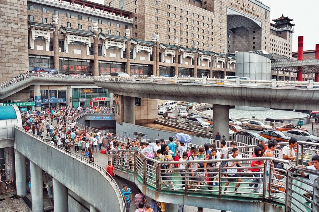 dav lidí mířící na hlavní nádraží v Pekingu